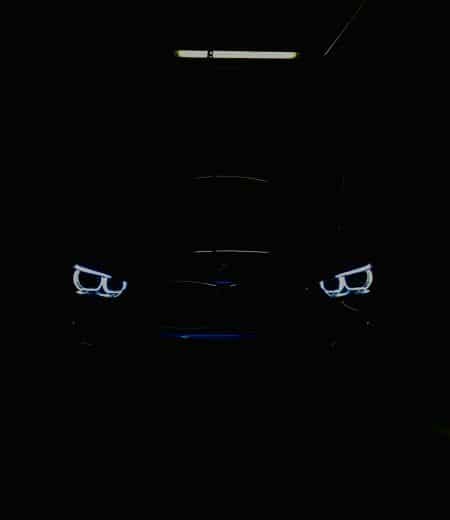 black car in the dark with lighted daytime running lights