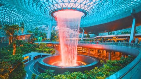 Illustration de l'aéroport de Singapour Changi avec la spectaculaire cascade intérieure Rain Vortex. Image réalisée par IA.