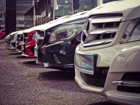 Acheter une voiture d’occasion en ligne : conseils pratiques pour un achat sécurisé et éclairé Luxury cars lined up at an outdoor dealership, showcasing sleek designs.