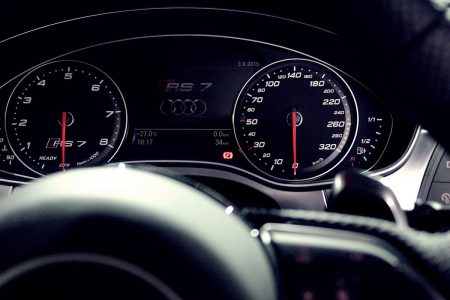 Un passionné transforme une vieille Audi en RS4 grâce à des achats malins sur Temu Close-up view of a luxury car dashboard featuring speedometer and gauges at night.
