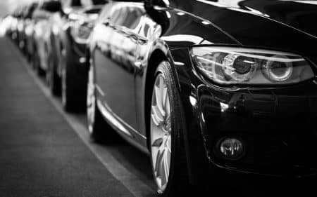 Guide complet pour remplacer les pièces de votre BMW en toute confiance Close-up black and white image of a luxury car line-up focusing on vehicle headlights.