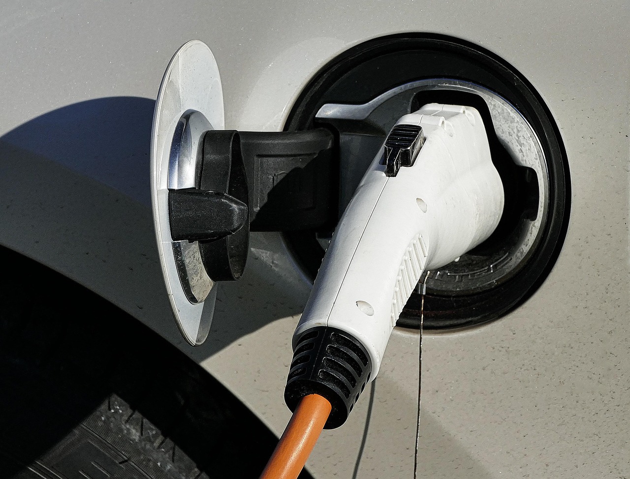 Une prise de recharge blanche branchée dans le port d’une voiture électrique